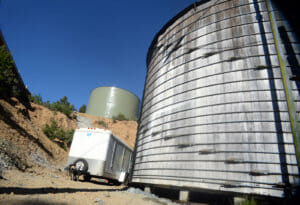 Shelter Cover water storage tank replacement. Old tank in foreground and new tank in background.