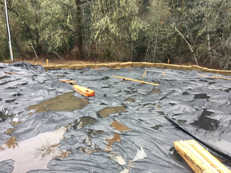 Contaminated soil is covered by tarps.